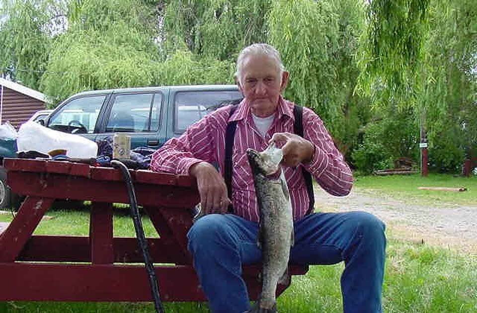 Angler seated at a picnic table with his trout